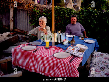 couple sitting at rustic setting outside waiting for dinner Stock Photo
