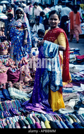 Female market traders selling sari and bags in outdoor market, Goa, India Stock Photo