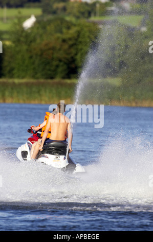 two teenage boys on yamaha 4 stroke waverunner jetski at speed on the river bann county antrim northern ireland Stock Photo