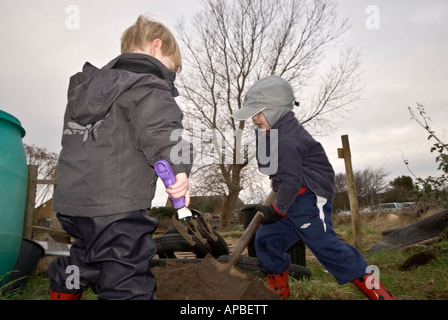 Two boy children digging allotment Stock Photo