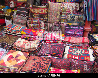 Piles of mats and cushions, bags on a market stall selling traditional Turkish patterned fabrics Stock Photo