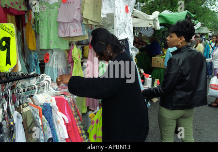 Women shopping for clothes at market stall Peckham Southwark London UK Stock Photo