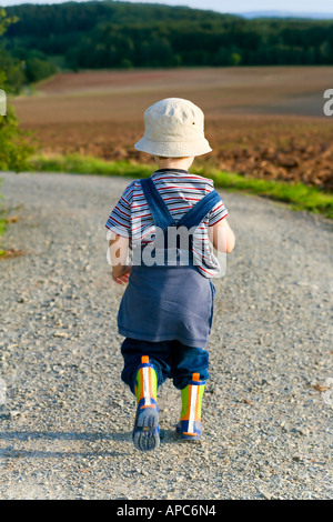 A three years old boy is walking on a track Stock Photo