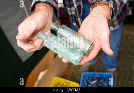 Man holding two empty bottles of Benbows Doc Mixture,  antiques antique market Stock Photo