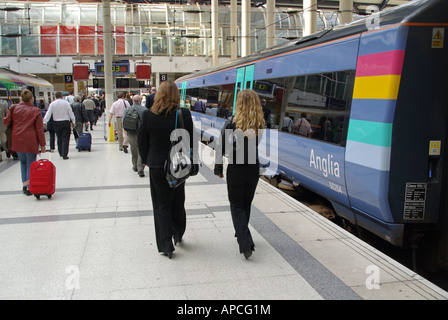 Liverpool Street railway station platform Greater Anglia trains just arrived back view of morning commuters walking to the exit London England UK Stock Photo