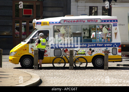 City of London cycle policeman in discussion with driver of a mobile ice cream sales commercial vehicle business van parked outside St Pauls Cathedral Stock Photo