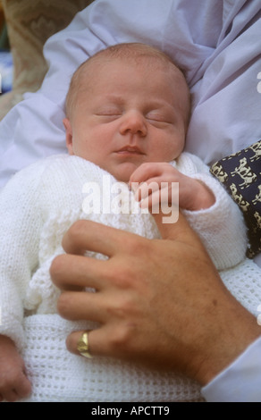 Baby boy, asleep, holding father's thumb Stock Photo