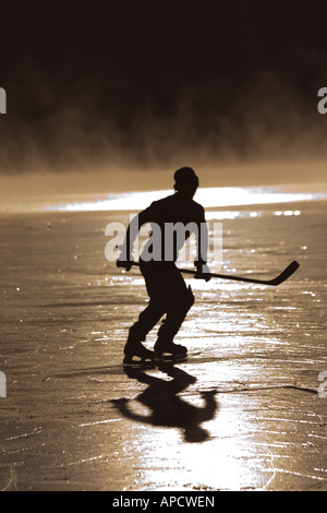 A skater and mist on frozen Donner Lake California at sunrise Stock Photo