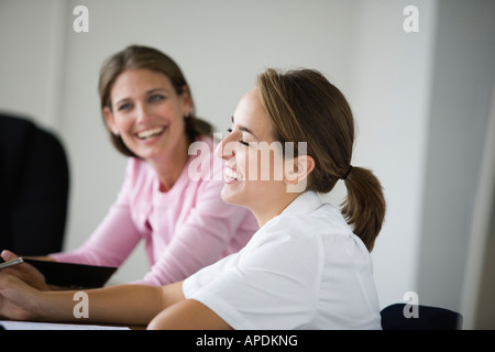 Side view of two women smiling. Stock Photo