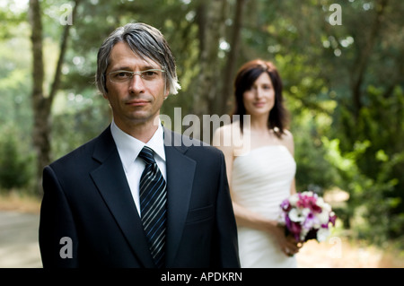 Bridegroom portrait with bride in background Stock Photo