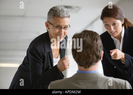 Two businesswomen interrogating a man. Stock Photo