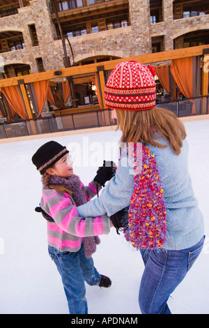 A mother and daughter dancing together on ice skates at Northstar ski resort near Lake Tahoe in California Stock Photo