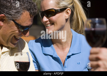 A happy couple smiling and drinking wine at Northstar ski resort near Lake Tahoe in California Stock Photo