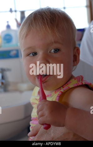 A toddler brushing her teeth before bedtime Stock Photo