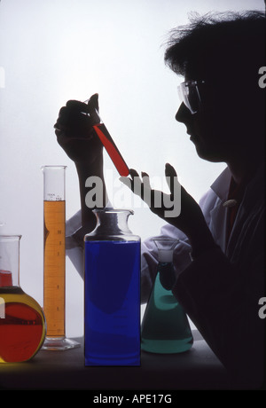 Chemist examines liquid in cylinder Stock Photo