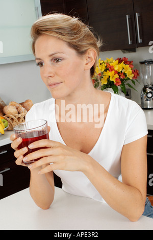 Young woman drinking cranberry juice Stock Photo - Alamy