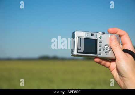 Young woman taking landscape picture with digital camera, close-up Stock Photo