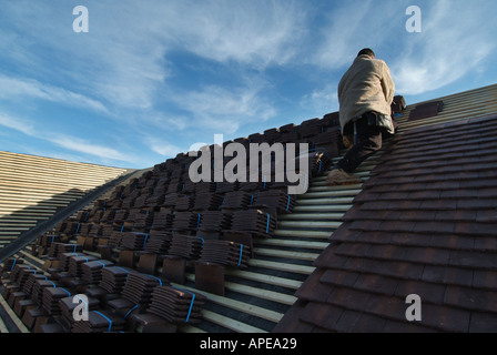 Detached house under construction roof tiling in progress on a cold winter day Stock Photo