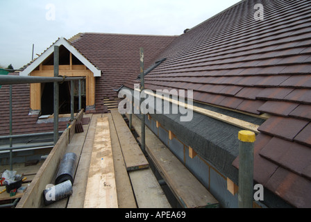 Part tiled roof to new detached house includes dormer window under construction Stock Photo