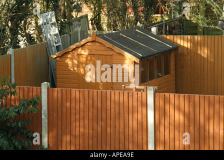 Aerial view looking down from above at house back garden timber fencing panels & concrete fence posts and wood garden shed with aluminium ladder UK Stock Photo