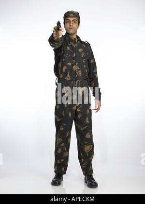 Indian army soldier standing in relaxed position aiming handgun Stock Photo