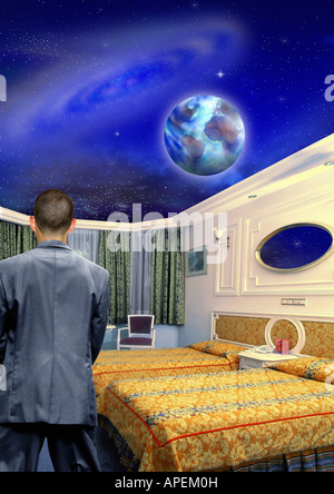 Man in surreal room with open ceiling, earth in sky. Stock Photo