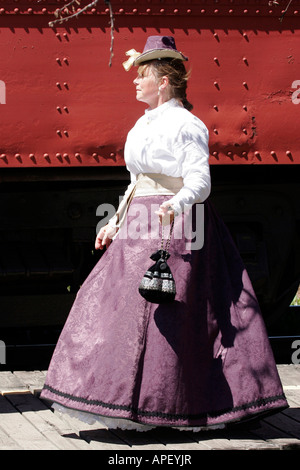 A classy and prime and proper women traveler walking the boardwalk at a train station in front of a train Stock Photo