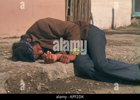 An alcoholic man passed out on the sidewalk Stock Photo