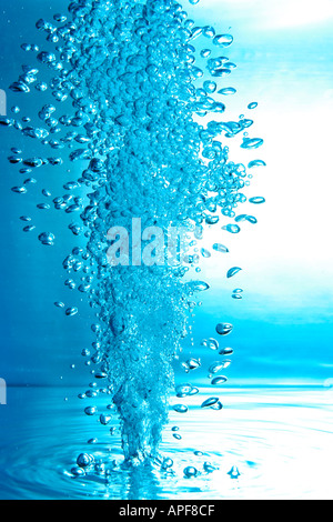 air bubbles water jet gets through water surface picture is turned by 180 degrees Stock Photo