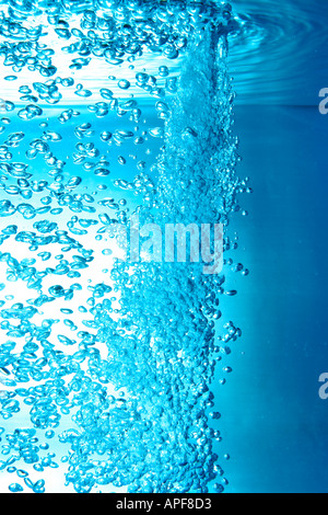 air bubbles water jet gets through water surface Stock Photo