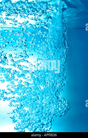 air bubbles water jet gets through water surface Stock Photo