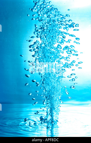 air bubbles water jet gets through water surface picture is turned by 180 degrees Stock Photo