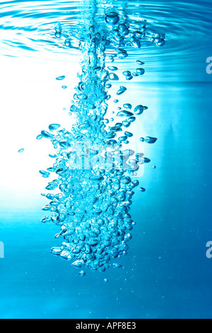 air bubbles water jet gets through water surface Stock Photo