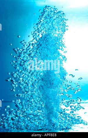 air bubbles water jet gets through water surface picture is turned by 180 degrees Stock Photo