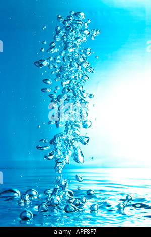 air bubbles water jet gets through water surface picture is turned by 180 degrees Stock Photo