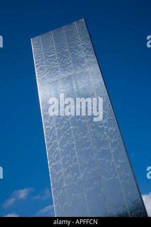 Water tower sculpture in Cardiff Bay with water cascading down the steel surface viewed against an almost clear blue sky Stock Photo