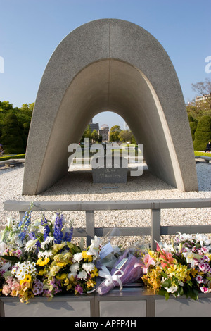 Flowers at the Cenotaph A bomb memorial and Flame Of Peace with a view on the A Bomb Dome in Hiroshima Japan Stock Photo