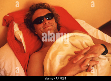 Surfer in bed with sunglasses, James Hendy, Portugal. Stock Photo