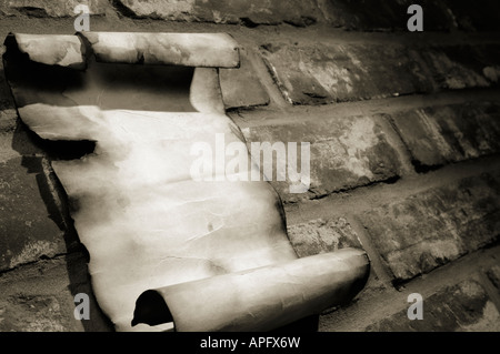 Old parchment on a brick wall Stock Photo