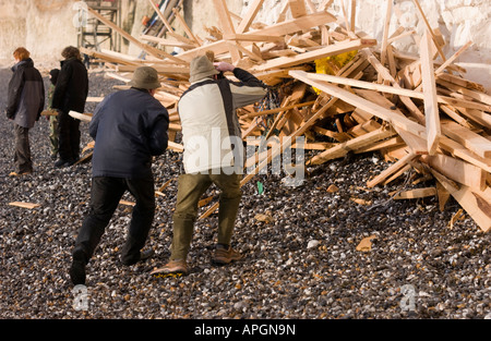Two men at Birling Gap take photographs of the sawn timber washed ashore from the stricken Ice Prince cargo ship. Stock Photo