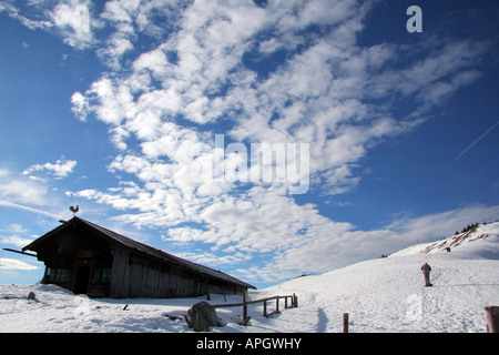 lonely hut in winter landscape against a beautiful cloudy sky in the Bavarian Alps Germany Europe Stock Photo