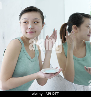 Young woman looking over her shoulder in bathroom Stock Photo