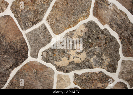 Detail from an old fashioned stone wall pattern with different sizes of stone lit with studio strobes Stock Photo