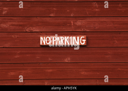 Hand painted No Parking sign on the side of a wooden hut. Stock Photo