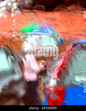 Driving rain: impressionistic image of two women caught in rainstorm seen through rain-soaked car windscreen Stock Photo