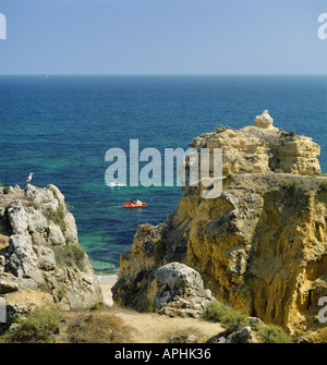 Portugal the Algarve Sao Rafael beach near Albufeira cliffs in summer, glimpse of beach and two pedalos Stock Photo