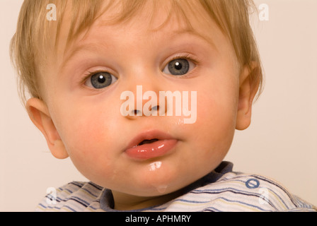 Baby boy eleven months old dribbling due to teething, wet chin Stock Photo