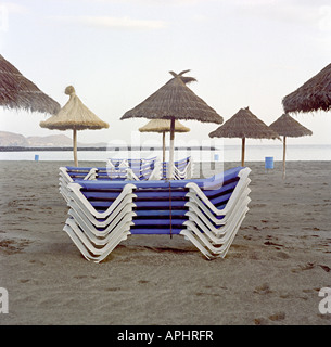 beach loungers on a beach with sun shades on a beach in tenerife Stock Photo