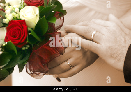 Wedding couples hands with ring and bouquet Stock Photo