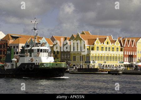 Willemstad's Punda waterfront, pastel Dutch architecture on Handelskade, with tugboat in channel to Sint Ana Baai Stock Photo